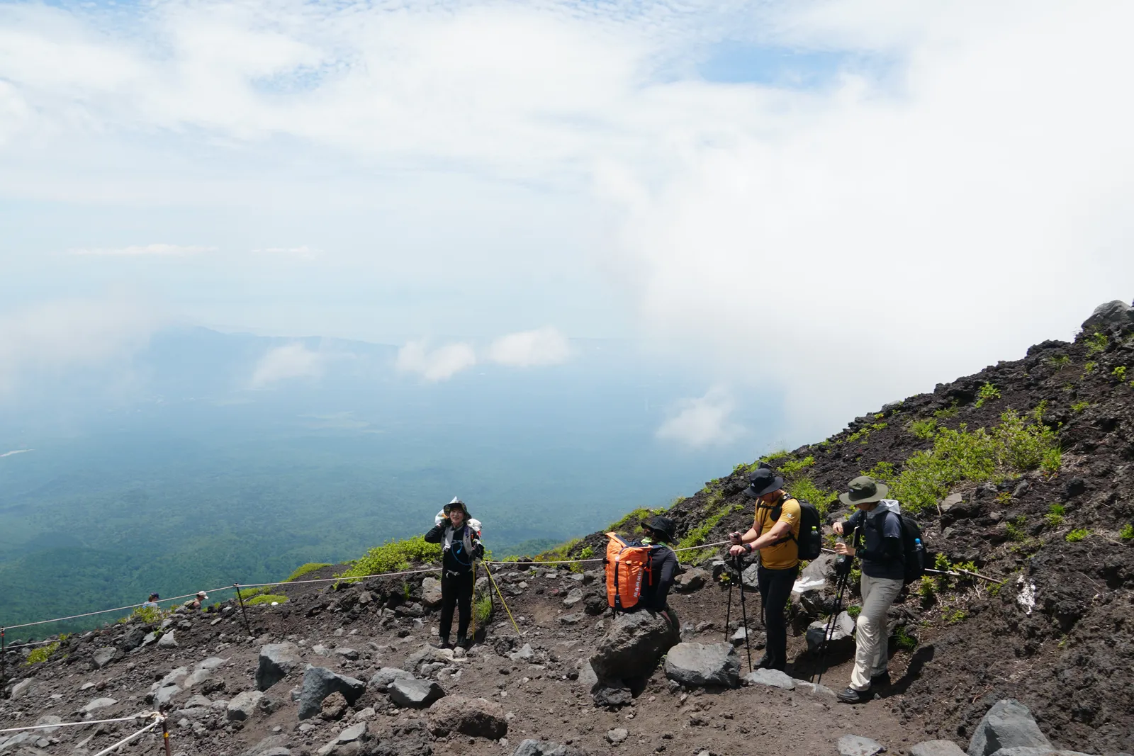 富士山好天氣時登山者行走在裸露火山地形上的實際畫面