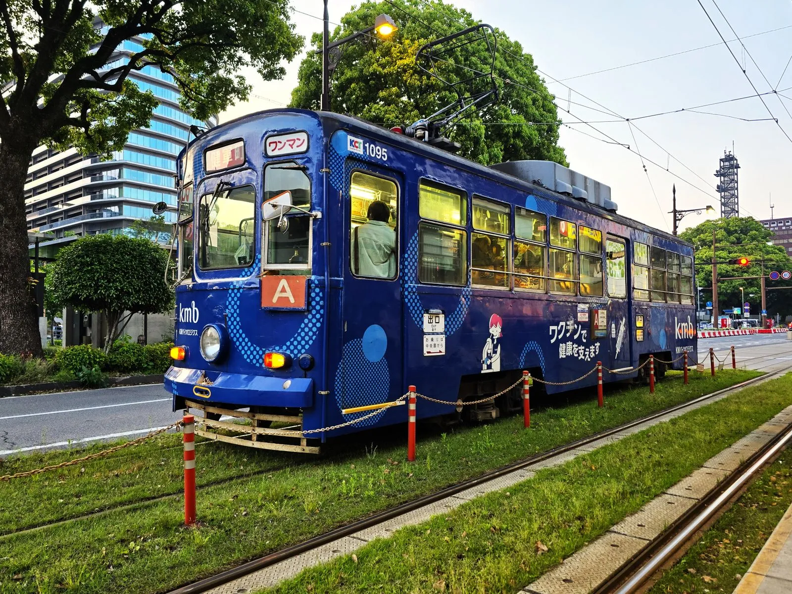 行駛於市區綠色軌道上的熊本路面電車