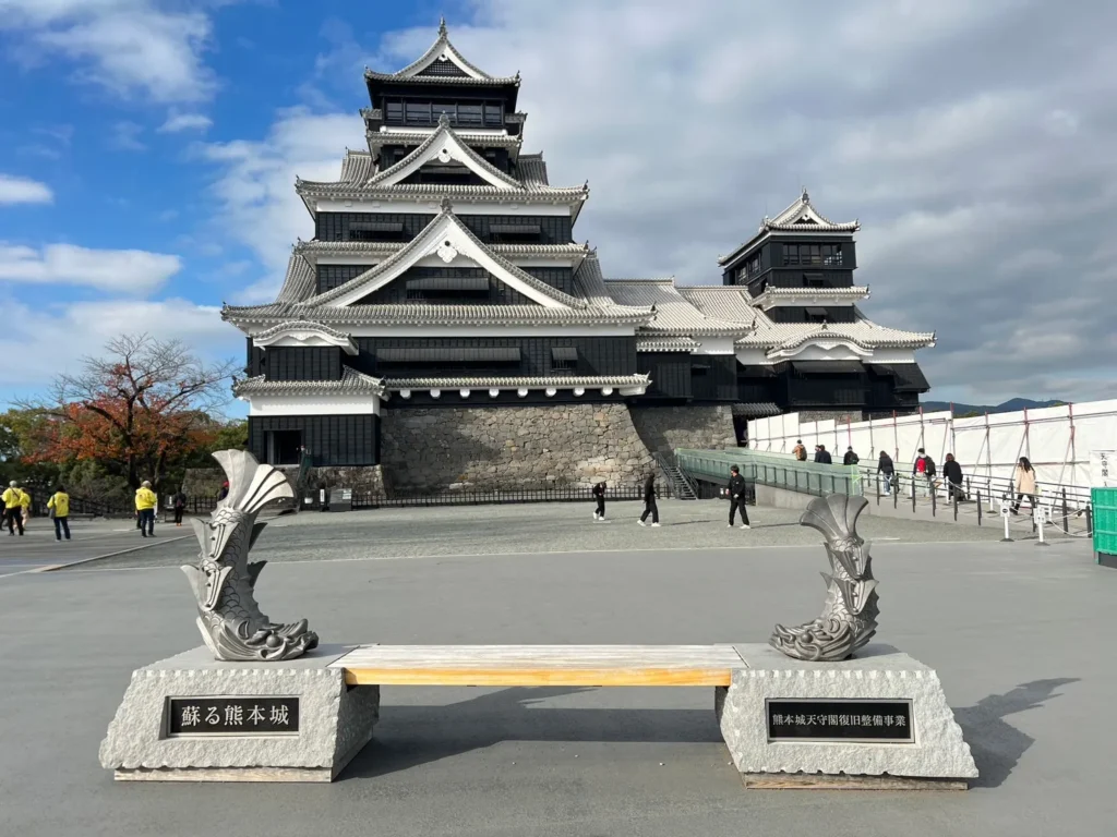 黑色熊本城天守閣與前方雕塑